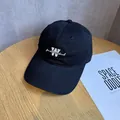Top view of black cotton baseball cap with white W letter embroidery on a wooden table - Adjustable / Black