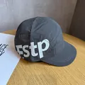 Detail shot of a dark grey five-panel camper cap with fstp print on a wood surface - Adjustable / Gray