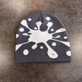 Dettaglio del berretto in maglia grigia con motivo artistico a macchie bianche - M (52-58cm) / Grigio