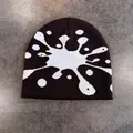 Dettaglio ravvicinato del berretto in maglia con motivo jacquard a schizzi bianco e nero - M (52-58cm) / caffè