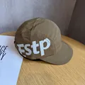 Detail of a dark khaki nylon camp hat with large white ESTP print on a wooden desk - Adjustable / Brown