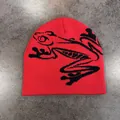 Dettaglio del berretto in maglia rossa con motivo jacquard a rana nera e doppio strato spesso - M (52-58cm) / Rosso