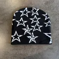 Close-up of black knitted beanie featuring white star pattern and fine jacquard texture - M / Black With White Stars
