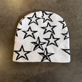 Close-up of high-quality white knitted beanie featuring black jacquard star patterns - M / White With Black Stars