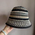 Close-up of hand-woven crochet texture on a striped straw bucket hat for women - M / Black