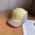 Detail of ripstop nylon camper hat featuring yellow and grey panels with red trim - Yellow