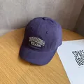 Dettaglio macro della trama in velluto a coste viola e del logo ricamato sul berretto - Regolabile / Viola