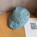 Gros plan d'une casquette gavroche bleu clair en lin sur une surface en bois - M / Bleu sarcelle