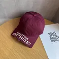 Dettaglio della visiera consumata e del ricamo bianco su un cappellino bordeaux - Regolabile / Borgogna