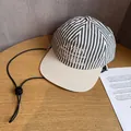 Detail of striped baseball cap with embroidery and adjustable windproof cord on wood - Adult (55-60cm) / Striped Black
