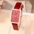 Macro shot of rectangular rose gold quartz watch with a textured burgundy leather strap - Red