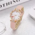 Close-up of pink quartz watch with rose gold wavy bezel and rhinestone heart pattern - White Dial Pink Strap