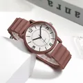 Detailansicht der weißen Quarzuhr mit geripptem braunem Silikonarmband im Makro - Kaffeebraun
