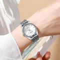 Detailed shot of a silver quartz watch with rhinestone bezel on a woman's wrist - Silver Case White Dial