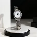 Dettaglio di un orologio al quarzo vintage con cinturino in metallo argento su marmo - Indici Bianco