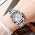Close-up of a women's silver quartz watch with a sparkling diamond bezel on a wrist - Silver White