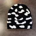 Detail of black knit beanie with white cow print texture and soft ribbed cuff - S (52-59cm) / Black