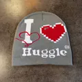 Detail van grijze gebreide muts met Huggle-belettering en rood pixelgekleurd hartdessin - M / Grijs