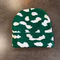 Makro-Detail einer dunkelgrünen Strickmütze mit weißen Wolkenmustern und umgeschlagenem Rand - S (52-59cm) / Grün