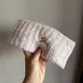 Detail view of pink knit headband with delicate embroidered puppy and wool texture - Pink