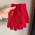 Detail von roten Strickhandschuhen mit gelber Stickerei und Rippstrickbündchen - Sicherheit und Frieden