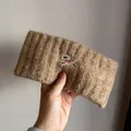 Close-up of a warm brown knitted headband with detailed puppy embroidery and thick texture - Camel