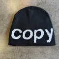 Detail view of the fine knit texture and woven copy lettering on this black beanie hat - M (54-59cm) / Black