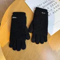 Close-up of black knitted gloves featuring a hollow texture and metal Fashion tag - One Size / Black