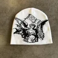 Detailopname van witte gebreide muts met zwart engel jacquard patroon en zachte stof - M (54-60cm) / Wit