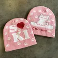 Dettaglio berretti in maglia rosa con lettere SKI bianche e motivi a cuore invernali - M (54-60cm) / Doppia Faccia Rosa