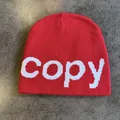 Detail of red knitted beanie featuring white copy text jacquard and warm ribbed texture - M (54-59cm) / Red