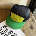 Detail of breathable black mesh and yellow panel on a color-block camper cap - Adjustable / Green Brim