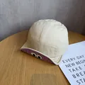 Detail of a beige five-panel baseball cap with purple brim and cute eye embroidery - Adjustable / Beige