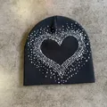 Close-up of a black knit beanie featuring a white pixelated heart pattern detail - M (52-59) / Black