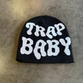 Close-up of black knit beanie featuring white TRAP BABY jacquard lettering detail - Black