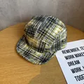 Dettaglio del cappellino a 5 pannelli a quadri gialli e neri con occhielli in metallo - Regolabile / Giallo e Nero