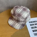 Dettaglio di un cappello vintage a cinque pannelli con motivo a quadri bordeaux e beige - Regolabile / Borgogna