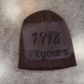 Close-up of dark brown knit beanie featuring black 1918 ENCORE text on grey stone surface - M (54-59cm) / Coffee