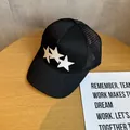 Dettaglio del cappello trucker nero con stelle di pelle bianca e rete traspirante - Regolabile / Nero