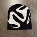 Vista piatta del berretto in maglia bianco e nero con motivo jacquard astratto street - M / Nero