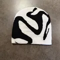 Dettaglio del berretto in maglia jacquard bianco e nero con motivo astratto street style - M / Bianco