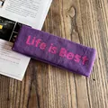 Détail d'un bandeau large tricoté violet avec texte rose sur fond en bois naturel - Violet