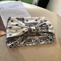 Bohemian paisley elastic headband in white with black pattern and central knot design - White