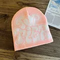 Detailed knit texture of pink beanie with white jacquard Top Tier lettering on wood - One Size / Light Pink