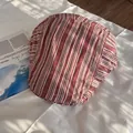 Detalle de una gorra plana clásica con rayas verticales rojas y marrones en tela suave - Ajustable / Rojo Oscuro