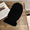 Detail of black knitted balaclava with ribbed texture and single-hole eye opening - Black