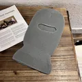 Detailed knit texture of a grey single-hole balaclava mask on a wooden surface - Gray
