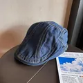 Detail der dunkelblauen Denim-Schirmmütze mit gelben Kontrastnähten und Metallschnalle - M / Dunkelblau