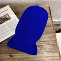 Detail of blue knitted balaclava with warm thick texture on wooden surface - Sapphire Blue