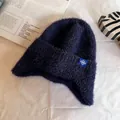 Detail of navy blue fuzzy knit trapper hat with soft faux fur texture and snowflake patch - One Size / Navy Blue